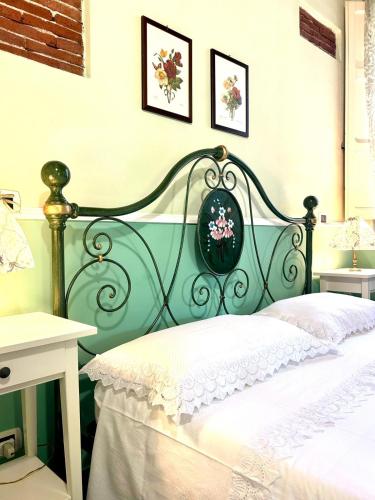 a bedroom with a green and white bed with flowers on the wall at Case Di Loco Castro in Agnone Bagni