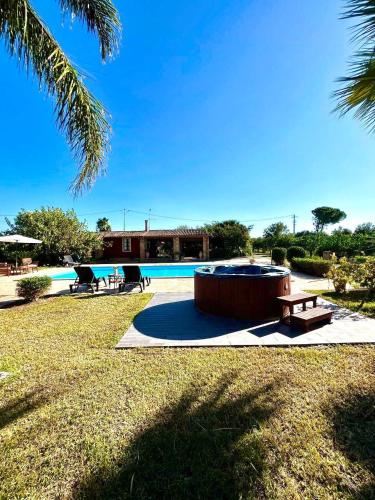 a pool with a hot tub and a picnic table at Case Di Loco Castro in Agnone Bagni