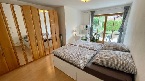 a small bedroom with a bed and a window at Casa Banniza in Wolfratshausen
