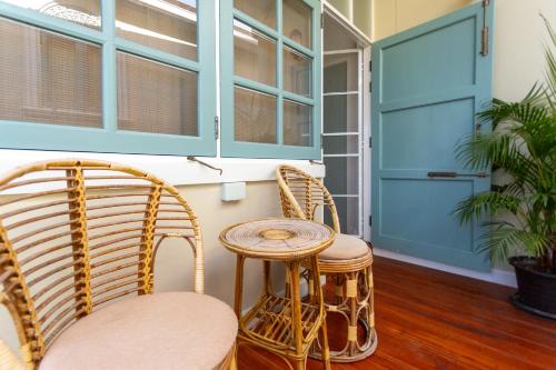 a room with wicker chairs and a blue door at Pran At Kumuang Boutique House in Chiang Mai
