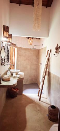 a bathroom with a sink and a ladder in a room at Guest House Villa 2 Santos in Arraial d'Ajuda