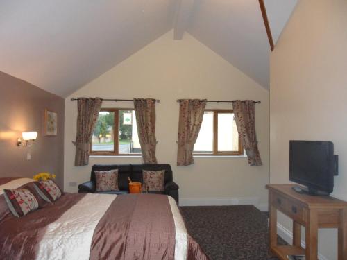 a bedroom with a bed and a tv in it at Old Oak Tree in Thirsk