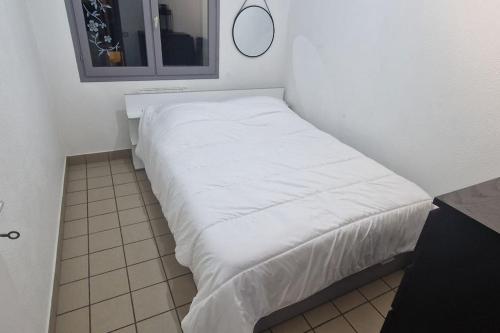 a white bed in a small room with a mirror at Au coeur de Vizille in Vizille