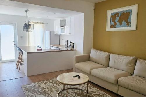 un salon avec un canapé et une table et une cuisine dans l'établissement Résidence des 4 mares, à Amfreville-la-Mi-Voie