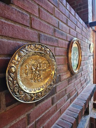 a wall with a gold plate on a brick wall at Private room - 1 in a luxury villa CHALET STYLE in Oslo