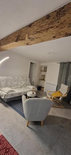 une chambre avec un lit, un canapé et une chaise dans l'établissement Appartement cosy et confortable, à Brié-et-Angonnes