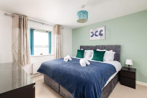 a bedroom with a large bed with towels on it at Home in Patchway in Bristol