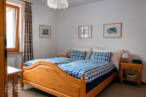 a bedroom with a wooden bed and a window at Pool & Sauna Wellness Charming Swiss style chalet! in Salouf