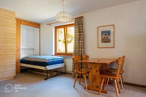 a bedroom with a bed and a table and chairs at Pool & Sauna Wellness Charming Swiss style chalet! in Salouf