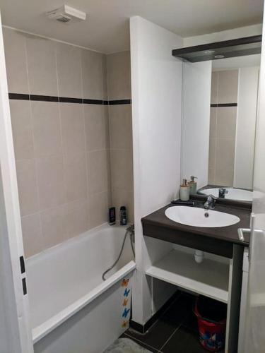 une salle de bain blanche avec un lavabo et une baignoire dans l'établissement Superbe deux pièces avec terrasse proche du métro, à Montreuil