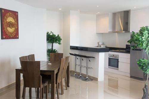 a kitchen with a wooden table and chairs in a kitchen at Tropical Sea View Residence in Lamai