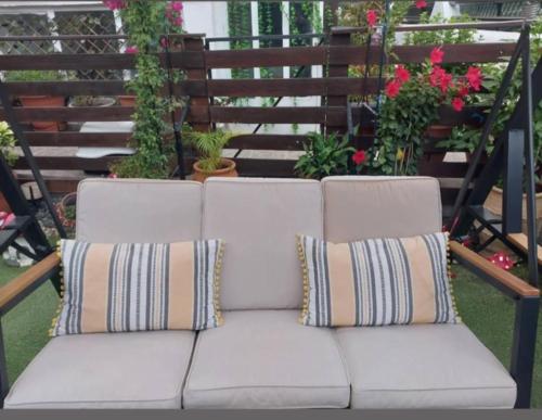 a white couch with two pillows on a patio at Zoe garden home in Spáta