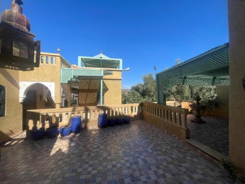a balcony of a house with blue barrels on it at Extrait d'atlas in Tafza