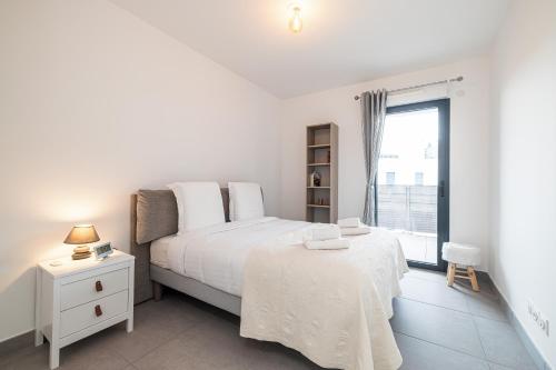 マントンにあるBienvenue 2 piece clim parkingのベッドと窓のある白い寝室