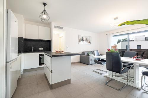 マントンにあるBienvenue 2 piece clim parkingのテーブルと椅子のあるキッチンとリビングルーム