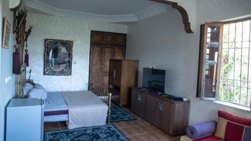 a bedroom with a bed and a tv in it at Extrait d'atlas in Tafza