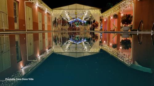 an indoor pool with christmas lights in a building at Pousada Casa Doce Vida in Águas de Lindóia