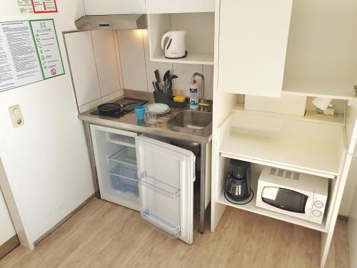 a small kitchen with a sink and a refrigerator at Aparthotel B & L in Bremen