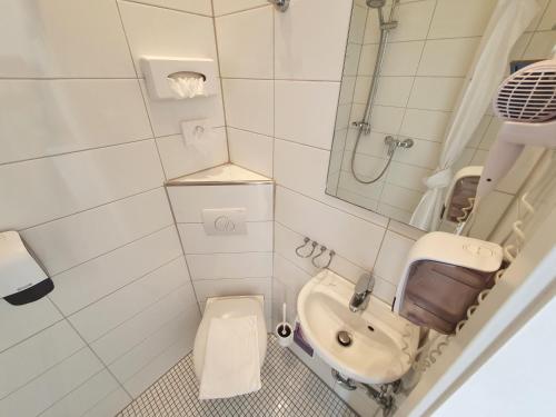 a small bathroom with a toilet and a sink at Aparthotel B & L in Bremen