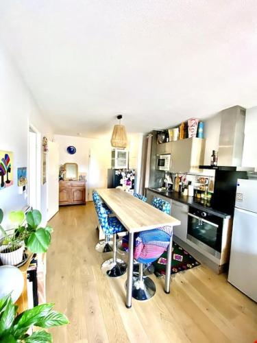 une cuisine avec une table et des chaises dans l'établissement Appartement cosy - balcon - parking gratuit - 10min centre ville, à Cenon