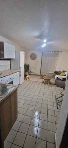 a kitchen with a refrigerator and a tiled floor at Au coeur de Vizille in Vizille