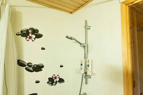 a bathroom with a shower with flowers on the wall at Lapland Aurora Suite by BookLapland in Rovaniemi