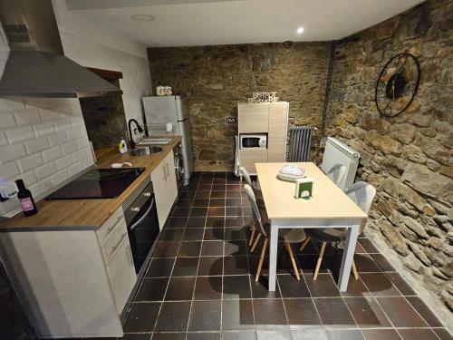 a kitchen with a table and a counter top at Casita con encanto, les gaites in Collanzo