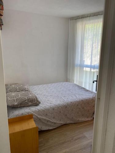 une chambre avec un lit et une fenêtre dans l'établissement Appartement lumineux 2 ch, à Villard-de-Lans