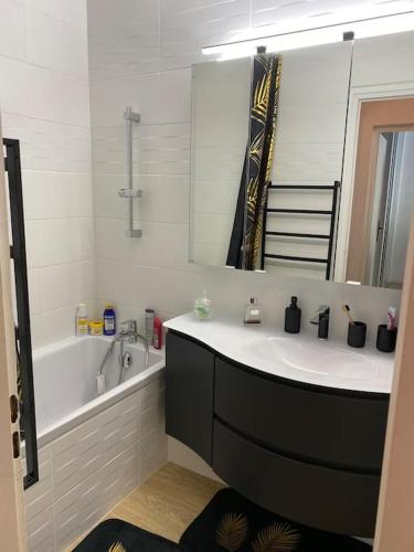 une salle de bain avec un lavabo, une baignoire et un miroir dans l'établissement Appartement lumineux 2 ch, à Villard-de-Lans