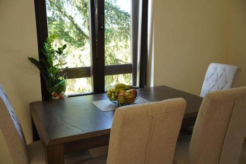 a dining room table with a bowl of fruit on it at Star Hill Apartments in Nova Varoš