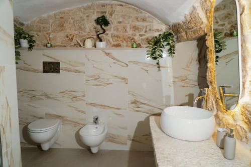 a bathroom with a sink and a toilet at Dimora di Sasso - Relax ed Eleganza nel Cuore della Puglia in Santeramo in Colle