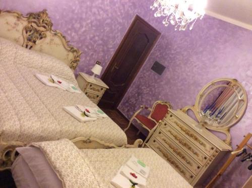 a bedroom with two beds and a chair and a chandelier at Appartamento I Cedri in San Cesareo