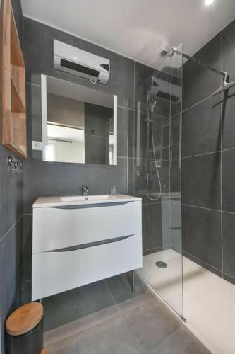 une salle de bain avec un lavabo blanc et une douche dans l'établissement Appartement 4 personnes entrée le Touquet avec terrasse et jardin, à Cucq