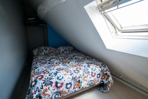 un petit lit dans une chambre avec une fenêtre dans l'établissement LA PERLE APPART - PLEIN CENTRE VILLE Orléans, à Orléans