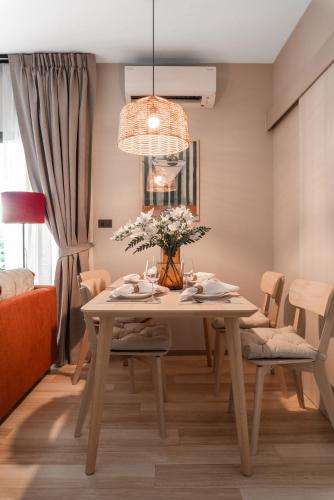 a dining room with a table with flowers on it at Title Halo Orange Sunset 46m2 Naiyang Pool&Gym in Nai Yang Beach
