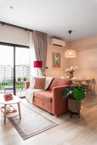 a living room with a couch and a table at Title Halo Orange Sunset 46m2 Naiyang Pool&Gym in Nai Yang Beach
