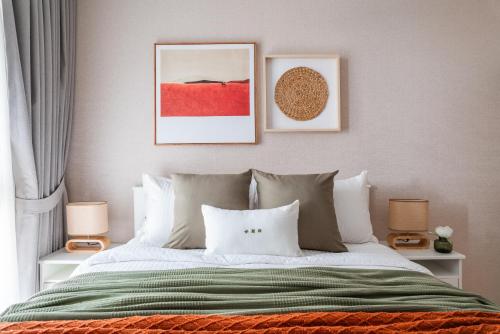 a bedroom with a bed with a green blanket and two lamps at Title Halo Orange Sunset 46m2 Naiyang Pool&Gym in Nai Yang Beach