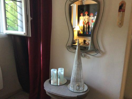 a mirror and a vase on a table in a room at La Parenthèse in Montluçon