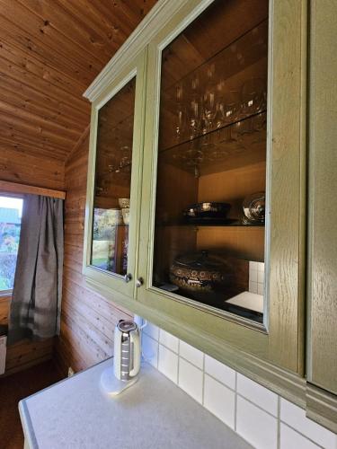 a kitchen with a cupboard with dishes in it at Private room - 6 in a luxury villa CHALET STYLE in Oslo