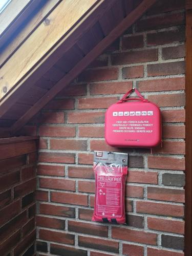 a red kit hanging on a brick wall at Private room - 6 in a luxury villa CHALET STYLE in Oslo