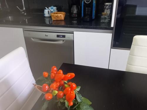 a vase of tomatoes on a table in a kitchen at Vista para a serra in Bragança