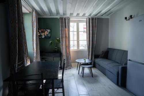 un salon avec un canapé et une table dans l'établissement L'ORLÉANAIS 1 - Appartement Spacieux Centre Ville, à Orléans