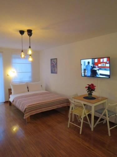 a bedroom with a bed and a tv on the wall at Moj kutak in Vrnjci