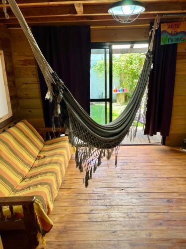 a hammock hanging in a room with a couch at Cabaña soles in Manuel Alberti