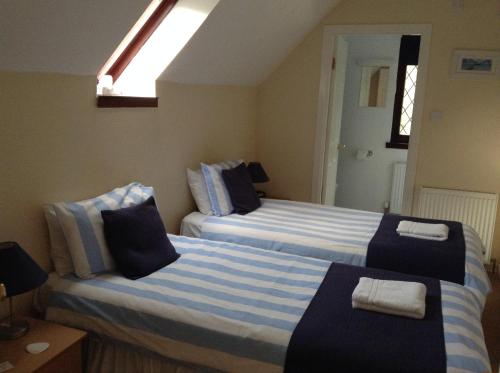 um quarto com 2 camas com riscas azuis e brancas em Darroch View B&B em Invermoriston
