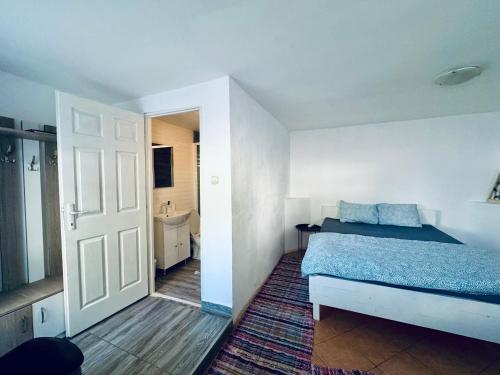 ein kleines Schlafzimmer mit einem Bett und einem Badezimmer in der Unterkunft Acasa in Bicaz-Chei - Camere de inchiriat Cheile Bicazului in Bicaz-Chei