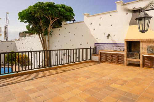 a balcony with a fireplace and a fence at Villa Altos de Santiago in Playa de Santiago