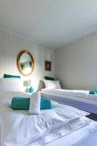 a bedroom with two beds and a mirror at La Casa Senja in Håverjorda