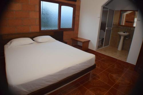 a bedroom with a bed and a bathroom with a shower at Finca Hotel Villa Mia in Girardota