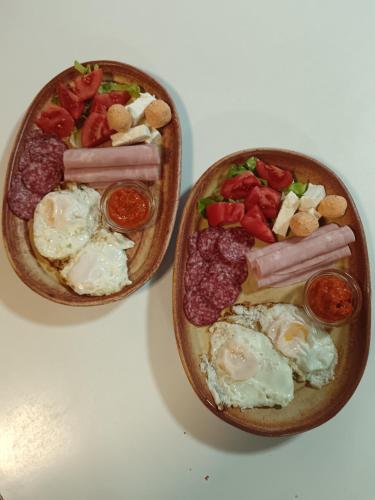 two bowls of food with eggs sausage and tomatoes at Etno selo Dukat in Belo Polje